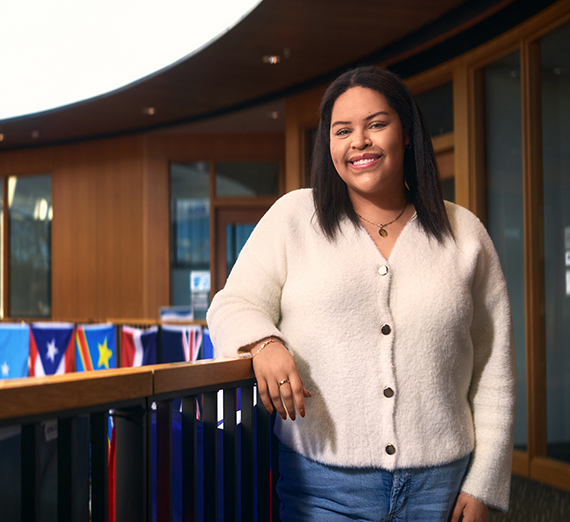 A woman in sunglasses claps in a crowd at a basketball game